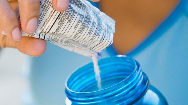 Woman mixing beverage with a drink mix 