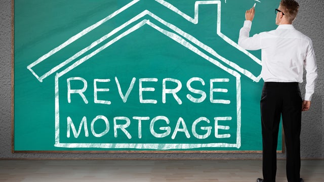Businessman Drawing House With Reverse Mortgage Text 